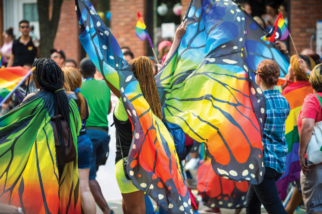 Gay pride carnival parade participants wearing colorful rainbow